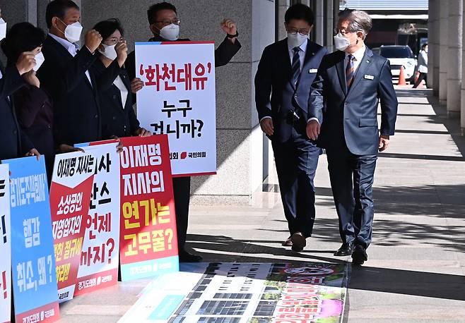 [수원=뉴시스] 김종택기자 = 더불어민주당 대선 주자인 이재명 경기지사가 15일 오전 경기도 수원시 경기도의회에서 열린 제354회 임시회 제4차 본회의에 출석하기 위해 청사로 들어서자 국민의힘 소속 경기도의원들이 화천대유 특혜 의혹 수사를 촉구하며 시위를 벌이고 있다. 2021.09.15. jtk@newsis.com