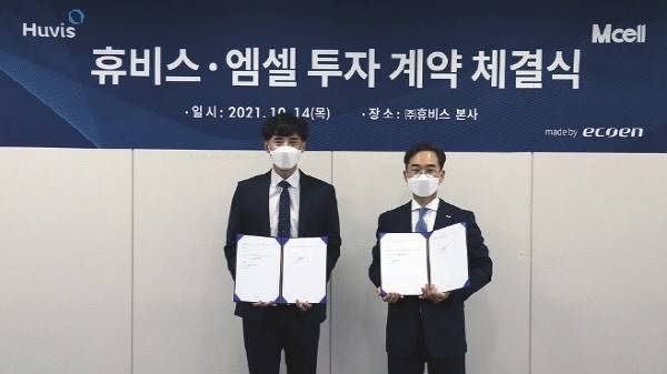 사진=휴비스 생분해 섬유 ‘에코엔’으로 제작한 현수막 앞에서 휴비스글로벌 신현섭 대표(우)와 엠셀 지승현 대표(좌)가 ‘투자 계약 체결식’ 기념사진을 촬영하고 있다.