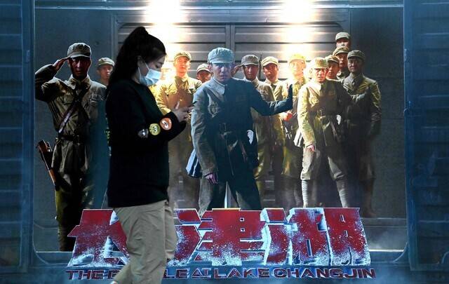 A person passes by an advertisement for the film “The Battle at Lake Changjin” outside of a movie theater in Beijing, China, on Monday. (AFP/Yonhap News)