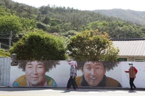 암태면 기동삼거리에 동백꽃 파마를 하고 수줍게 웃고 있는 노부부 벽화. [사진 조남대]