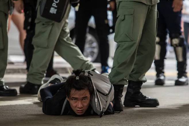 경찰들이 지난해 7월1일 홍콩의 한 거리에서 ‘홍콩 국가보안법’ 반대 시위에 참가한 시민 한 명을 연행하기 위해 결박해두고 있다. 홍콩보안법 시행 다음날인 이날 홍콩 곳곳에서 반대 시위가 벌어져 370명이 체포됐다. 홍콩 | AFP연합뉴스