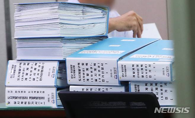 [성남=뉴시스] 김종택기자 = 15일 오후 대장동 개발 로비·특혜 의혹 사건 관련 검찰 압수수색이 진행 중인 경기도 성남시청 도시계획과 사무실 책상 위에 판교대장 도시개발사업 관련 서류들이 쌓여 있다. (공동취재사진) 2021.10.15. photo@newsis.com