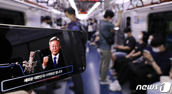1일 오전 한 시민이 지하철 1호선 안에서 더불어민주당 대선 주자인 이재명 경기지사의 제20대 대통령 선거 출마선언 라이브 방송을 스마트폰으로 시청하고 있다. 2021.7.1/뉴스1 © News1 김진환 기자