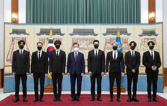 문재인 대통령이 9월 14일 청와대에서 열린 미래세대와 문화를 위한 대통령 특별사절 임명장 수여식에서 아이돌 그룹 방탄소년단(BTS)에게 임명장을 수여하고 기념촬영을 하고 있다. 왼쪽부터 뷔, 제이홉, 진, 문 대통령, RM, 슈가, 지민, 정국. 뉴스1