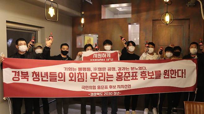 [대구=뉴시스]경북지역의 2030세대 청년 소상공인 50명이 16일 오후 경북 문경의 식당에서 지지성명을 발표하고 홍 후보의 별칭인 ‘홍카콜라’를 상징하는 콜라마시기 퍼포먼스를 펼치고 있다(사진=jp희망캠프 제공) 2021.10.16. photo@newsis.com *재판매 및 DB 금지