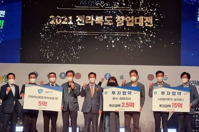 14일 전북 군산대에서 개막한 2021 전라북도 창업대전에서 우수 창업기업 2개사와 투자사 관계자들이 투자협약 선포식을 하며 파이팅을 외치고 있다. 전북도 제공
