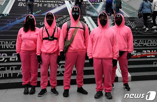 10일(현지시간) 뉴욕 제이컵 K. 재비츠 컨벤션 센터에서 열리고 있는 미국 최대의 엔터테인먼트 박람회인 '뉴욕 코믹콘' 서 넷플릭스의 드라마 '오징어게임'의 진행요원 캐릭터로 분장한 참가자들이 포즈를 취하고 있다. © AFP=뉴스1 © News1 우동명 기자