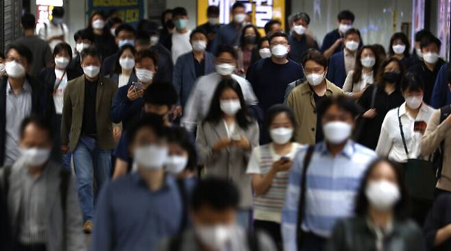 정부가 오는 18일부터 적용될 새로운 방역지침을 발표한 15일 오전 서울 지하철 광화문역에서 직장인 등 시민들이 걸어가고 있다. 연합뉴스