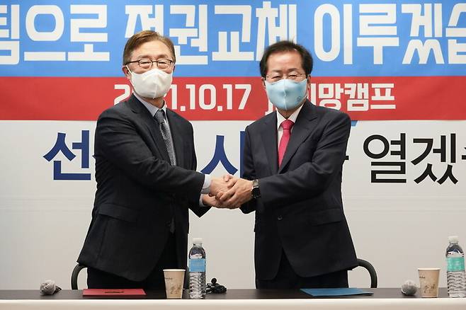 ▲홍준표 국민의힘 대선 경선후보와 최재형 전 감사원장은 17일 오전 서울 여의도 jp희망캠프에서 연 공동기자회견에서 악수하며 사진촬영하고 있다. 사진=홍준표 캠프