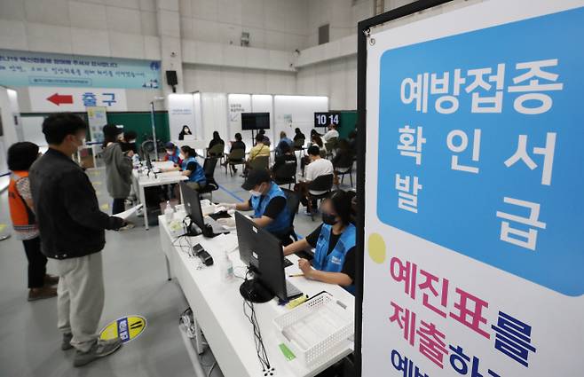 16∼17세 청소년에 대한 화이자 백신 접종 사전예약이 시작되는 5일 서울 동작구민체육센터에 마련된 예방접종센터에서 백신 접종을 마친 시민들이 예방접종확인서를 발급받고 있다. 연합뉴스