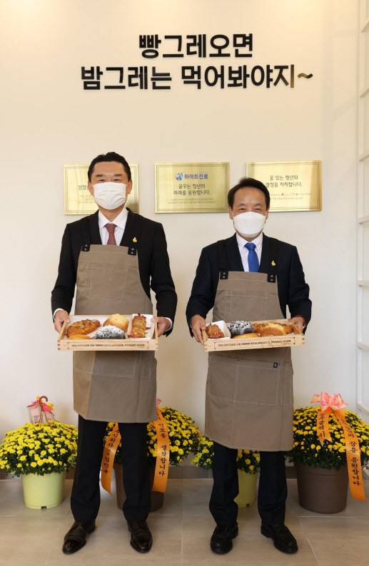 ▲19일 공식 개점한 광주광역시 동구 ‘빵그레 2호점’에서 김인규(왼쪽) 하이트진로 대표와 임택 광주광역시 동구청장이 함께 대표 메뉴를 선보이고 있다.(사진=하이트진로)