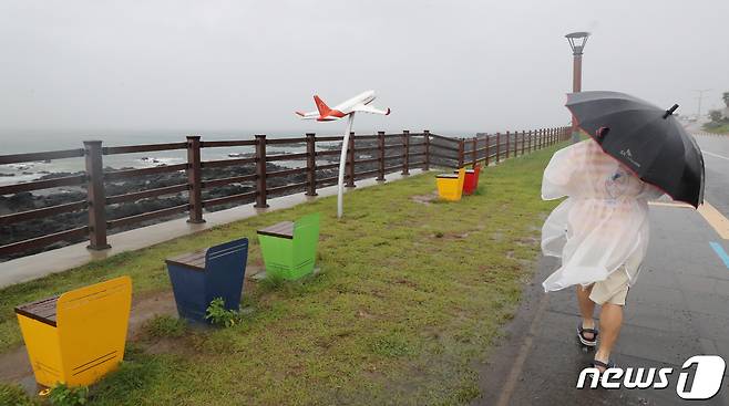 제주시 용담해안도로에서 우비를 입은 행인이 발걸음을 옮기고 있다. 2021.9.14/뉴스1 © News1 오현지 기자