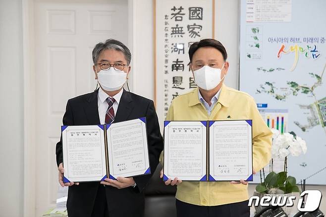 설영길 군산자동차무역 대표(사진 왼쪽)와 강임준 군산시장이 새만금 자동차 수출복합센터 조성을 위한 업무협약을 체결하고 있다.© 뉴스1