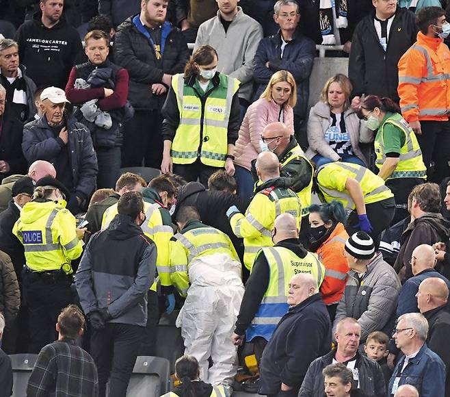 뉴캐슬과 토트넘의 18일 경기를 관중석에서 보던 한 남성 팬이 심장 이상으로 쓰러지자 의료진이 응급처치를 하고 있다. /EPA 연합뉴스