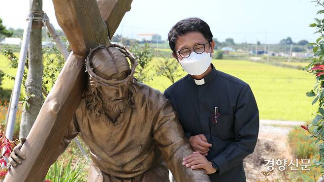 초남이성지 담당 김성봉 신부가 지난 5일 성지 십자가의 길에 설치된 예수상을 어루만지고 있다. 김종목 기자