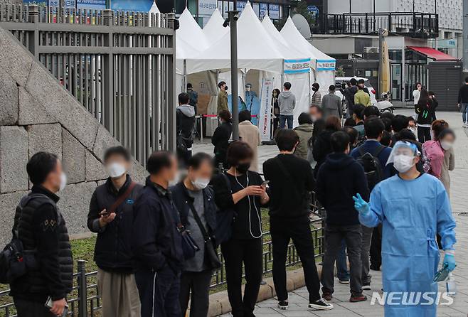 [서울=뉴시스] 권창회 기자 = 동대문종합시장 관련 확진자가 80명으로 집계된 19일 오전 서울 종로구 흥인지문 인근에 설치된 찾아가는 선별진료소에서 시장 종사자들이 검사를 받기 위해 대기하고 있다. 2021.10.19. kch0523@newsis.com