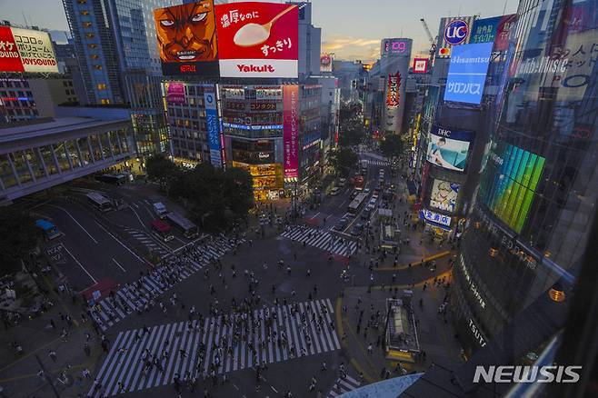 [도쿄=AP/뉴시스] 일본 도쿄 번화가 시부야에서 해가 저무는 11일 저녁 시민들이 교차 횡단보도를 바삐 건너고 있다. 2021.10.17