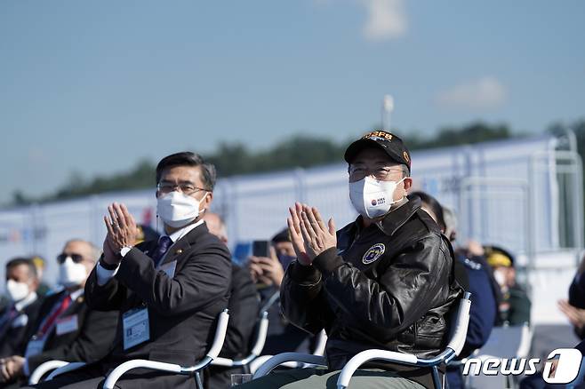 문재인 대통령이 20일 경기도 성남시 서울공항에서 열린 2021 서울 국제 항공우주 및 방위산업 전시회(ADEX) 개막 기념행사에 참석해 공군 특수비행팀 블랙이글스의 국산 고등훈련기 T-50편대의 축하비행을 보며 박수치고 있다. 2021.10.20/뉴스1 © News1 이광호 기자