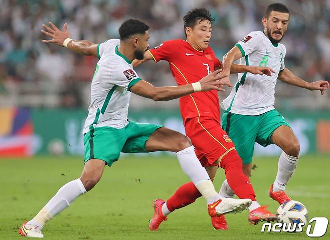 중국 대표팀 우레이(가운데)가 사우디아라비아 수비수 사이를 돌파하고 있다.© AFP=뉴스1