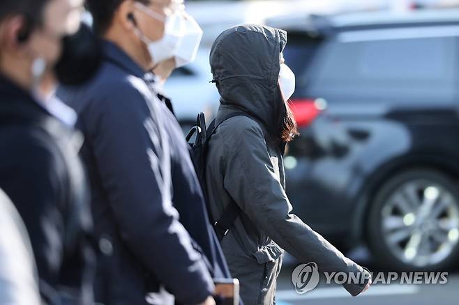 쌀쌀한 날씨 (서울=연합뉴스) 임화영 기자 = 아침 기온이 5도까지 내려가 쌀쌀한 날씨를 보인 20일 오전 서울 종로구 광화문네거리에서 외투 모자를 눌러 쓴 시민이 발걸음을 옮기고 있다. 2021.10.20 hwayoung7@yna.co.kr