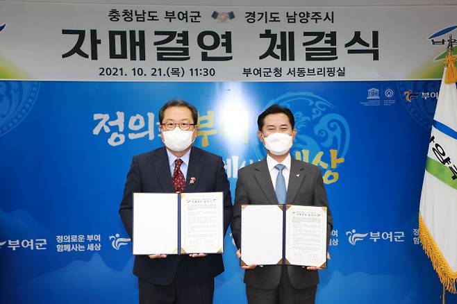 조광한 시장(왼쪽)과 박정현 부여군수가 협약서를 들어보이고 있다.(사진=남양주시 제공)