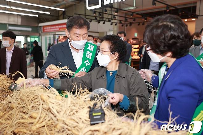21일 전북 진안군과 농협진안군지부가 농협하나로마트 전주점에서 ‘진안인삼 판로확대·소비촉진 직거래장터’를 열었다. 전춘성 진안군수(왼쪽 첫번째)가 인삼을 홍보하고 있다.(진안군제공)2021.10.21/뉴스1
