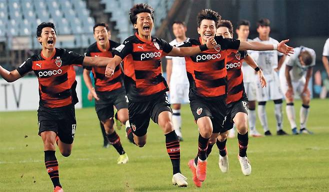 포항 스틸러스 선수들이 20일 전주월드컵경기장에서 열린 울산과의 아시아축구연맹(AFC) 챔피언스리그 4강전 승부차기에서 5대4로 승리한 뒤 포항 서포터스가 있는 관중석 쪽으로 두 팔을 벌려 달려가며 환호하고 있다. 포항은 다음 달 23일 AFC 챔피언스리그 결승에서 사우디아라비아의 알 힐랄과 아시아 최강 자리를 두고 한판 승부를 벌인다. /연합뉴스