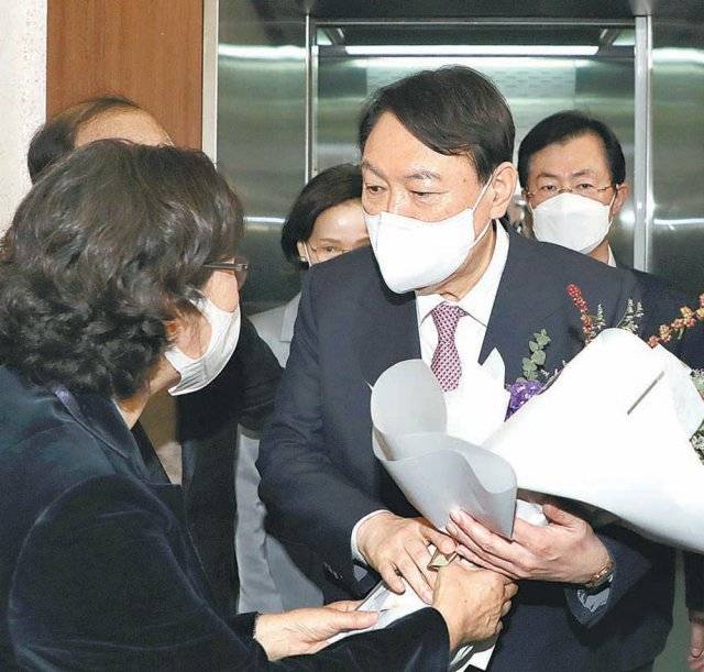 윤석열 전 검찰총장이 20일 대구 수성구 국민의힘 대구시당 강당에서 열린 대구경북선대위 임명장 수여식에서 지지자들로부터 환영 꽃다발을 받고 있다. 대구=뉴스1
