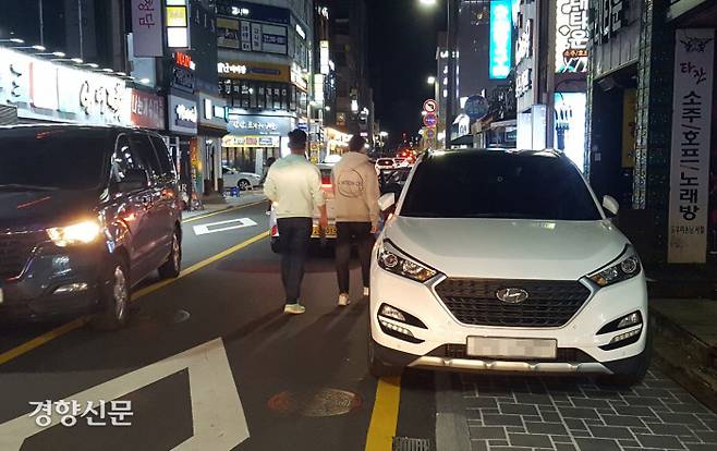 울산 남구 공업탑상가에서 시민들이 지난 20일 인도에 주차된 차량을 피해 차도로 걸어가고 있다.