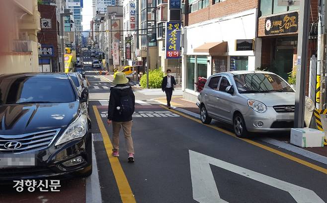 울산 남구 신정동 보행환경개선지구에서 시민들이 지난 20일 인도에 세워둔 차량때문에 차도로 걷고 있다.