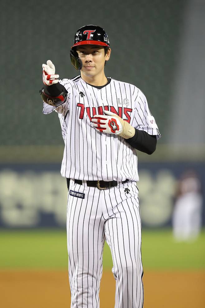 LG 홍창기가 21일 잠실구장에서 열린 키움전에서 안타를 날리고 출루한 뒤 더그아웃 동료들과 기쁨을 나누고 있다. LG 제공