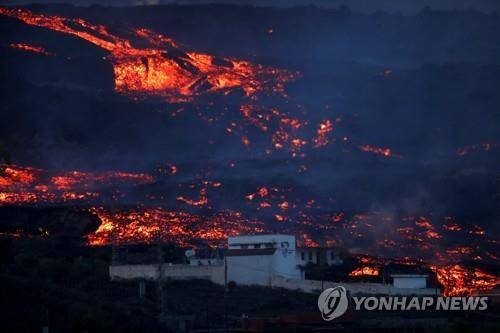 마을 뒤로 흐르는 뜨거운 용암 (엘파소 로이터=연합뉴스) 19일(현지시간) 스페인령 카나리아제도 라팔마섬 마을 뒤로 쿰브레 비에하 화산에서 흘러나온 용암이 흐르고 있다. 2021.10.20 photo@yna.co.kr