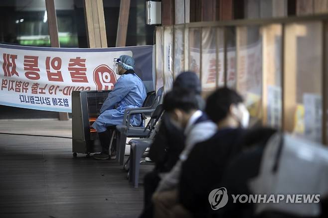 여러 계절을 거쳐 다시 겨울로 향하는 이 곳 (서울=연합뉴스) 윤동진 기자 = 국내 신종코로나바이러스 감염증(코로나19) 신규 확진자 수 1천400명대 중반을 기록한 21일 서울 송파구 보건소 선별진료소에서 한 관계자가 난로 앞에서 잠시 몸을 녹이고 있다. 2021.10.21 mon@yna.co.kr