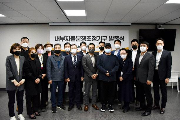 ▲지난 21일 서울 강동구 맘스터치 본사에서 열린 ‘내부자율분쟁조정기구 발족식’에서 이승창(앞줄 왼쪽 네번째) 초대 위원장과 김동전(앞둘 가운데) 맘스터치 대표이사, 가맹사업자대표 및 가맹본부대표들이 기념촬영을 하고 있다.(사진=맘스터치)