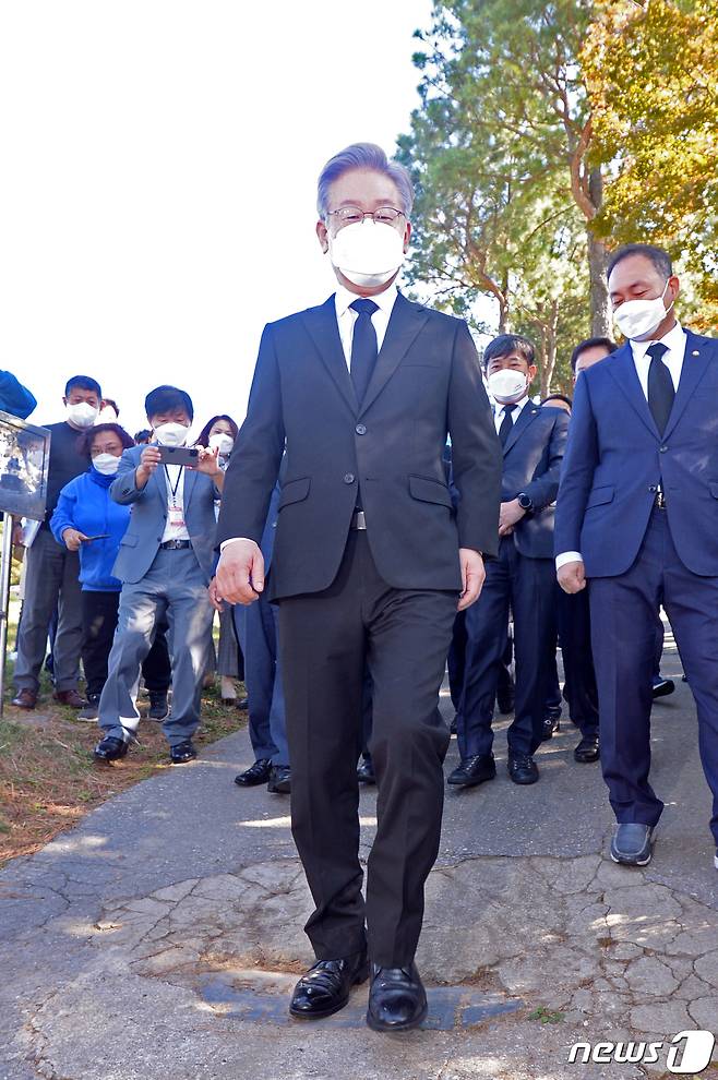 이재명 더불어민주당 대선후보가 22일 오전 광주 북구 망월동 민족민주열사묘역(5·18구묘역)을 찾아 전두환씨 기념비석을 밟고 있다. 이 비석은 1982년 전씨가 담양의 한 마을을 방문한 것을 기념하기 위해 세워졌으며, 이를 발견한 5월단체가 비석을 수거해 구 묘역을 방문하는 참배객이 밟을 수 있도록 땅에 묻어놨다. 2021.10.22/뉴스1 © News1 정다움 기자