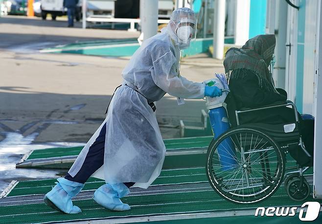 러시아 모스크바 한 종합병원에서 2021년 10월 13일 의료진이 코로나19 감염 환자를 휠체어에 태워 이동시키는 모습. © 로이터=뉴스1