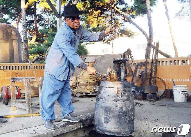 원광식 주철장이 거푸집에서 꺼낸 범종을 손질하고 있다.2021.10.22© 뉴스1
