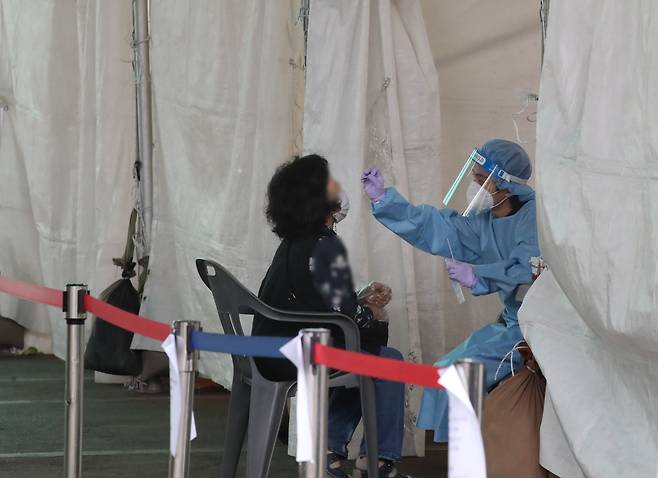지난달 30일 오전 서울 송파구 가락시장 '서울시 찾아가는 선별진료소'에서 시민이 검사를 받고 있다. /연합뉴스
