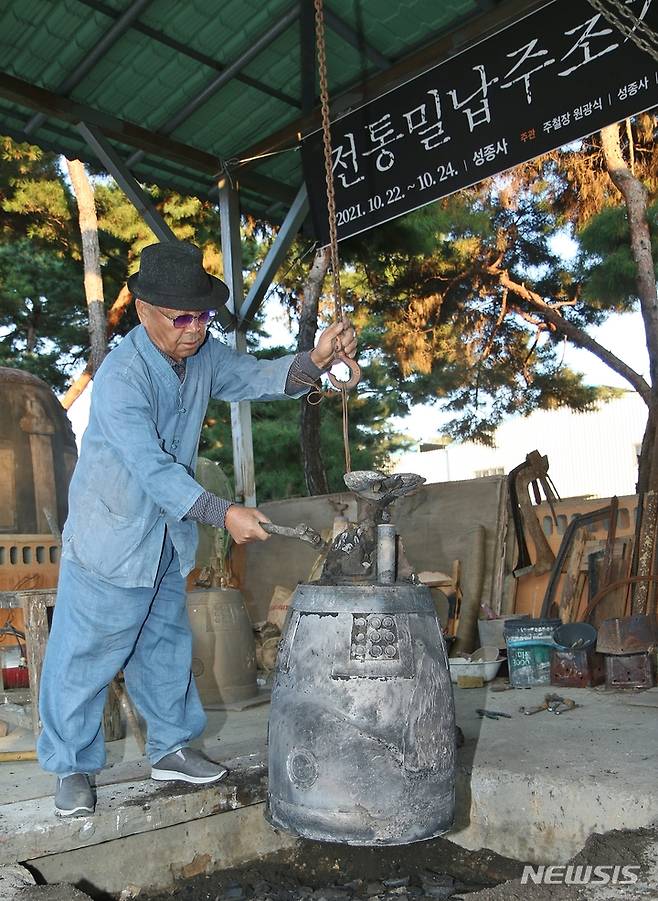 [진천=뉴시스] 강신욱 기자 = 국가무형문화재 112호 원광식 주철장이 22일 충북 진천군 덕산읍 성종사에서 전통밀랍주조기법으로 제작한 범종 거푸집을 해체하고 마무리 작업을 하고 있다. 2021.10.22. ksw64@newsis.com