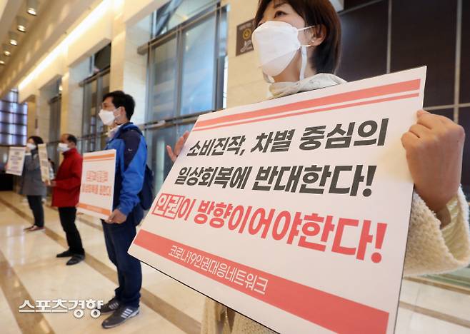 22일 서울 서초구 엘타워에서 열릴 ‘단계적 일상 회복’ 관련 2차 공개토론회를 앞두고 코로나19인권대응네트워크 회원들이 ‘위드코로나(단계적 일상회복)는 인권이 중심이 되어야 한다’는 피켓을 들고 시위를 하고 있다. 이날 시위 참석자들은 집회 시위의 권리보장, 차별과 불평등을 양산하는 백신 패스 중단 등을 촉구했다. 김기남 기자 kknphoto@kyunghyang.com