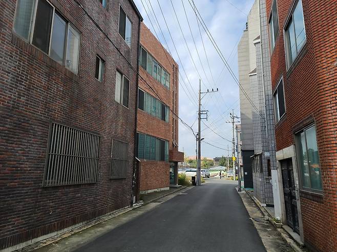 썰렁한 캠프워커 밖 재개발 지역 (대구=연합뉴스) 이재혁 기자 = 대구 남구 대명5동 캠프워커 담 밖 초고층 아파트 신축 예정지가 주민 이주로 썰렁한 모습을 보이고 있다. 멀리 정면에 보이는 붉은 지붕은 미군기지 내 시설. 2021.10.22