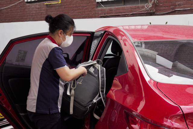 신씨가 정수기 점검을 마친 뒤 가방을 차량에 싣고 있다. 이들의 가방엔 살균 키트, 서비스 키트, 청소기, 정수기 필터, 직수관 등 점검을 위해 필요한 각종 장비가 가득 담겨 있다.