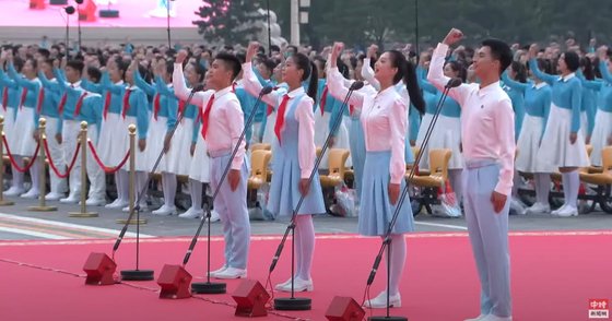 흰색 상의에 빨간 스카프를 두른 중국 청년들이 ”우리는 당에 충성을 맹세했다“며 주먹을 불끈 쥐었다. [중국신문망 캡쳐]