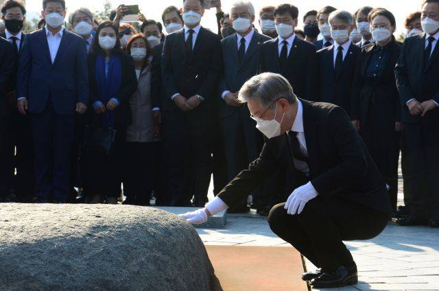 이재명 더불어민주당 대선후보가 지난 22일 오후 경남 김해시 봉하마을 고(故) 노무현 전 대통령 묘소에서 너럭바위를 만지고 있다. 뉴시스