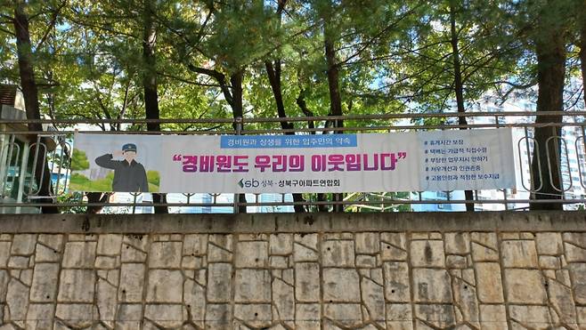 22일 오전 10시쯤 서울시 성북구의 한 아파트에 "경비원도 우리 이웃입니다"라 적힌 현수막이 붙어있다./사진=양윤우 기자.