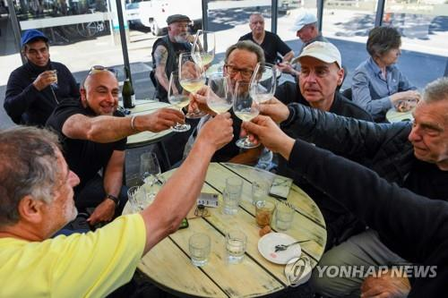 22일(현지시간) 봉쇄 조치가 해제된 호주 멜버른의 한 카페에서 시민들이 건배하고 있다./AFP연합뉴스