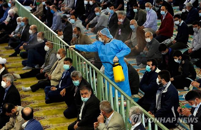 '모스크도 소독' (테헤란 AFP=연합뉴스) 22일(현지시간) 이란의 수도 테헤란의 한 모스크에서 무슬림들이 예배하는 가운데 방역 요원이 소독약을 뿌리고 있다. 2021.10.23 photo@yna.co.kr