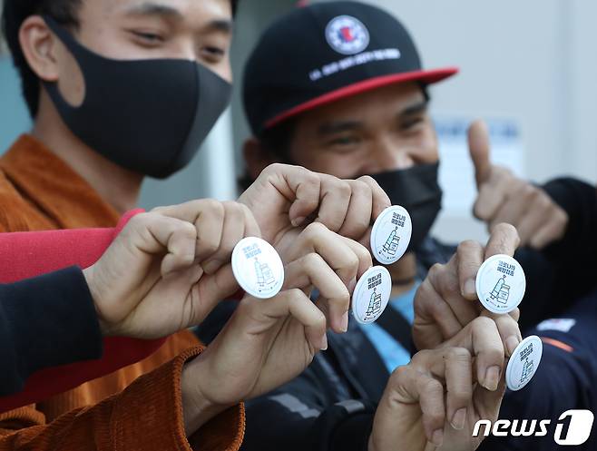 국내 코로나19 백신 접종 완료율이 70%를 돌파한 가운데 휴일인 24일 오전 대구육상진흥센터에 마련된 수성구예방접종센터에서 백신 접종을 마친 외국인 근로자들이 질병관리청과 대구시가 무료로 배포하는 '고마워 백신' 배지를 들어 보이고 있다. 2021.10.24/뉴스1 © News1 공정식 기자