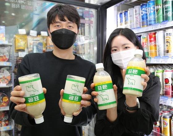 모델들이 GS25에서 출시하는 표곰 막걸리를 거꾸로 들고 포즈를 취하고 있다. [사진 GS25]