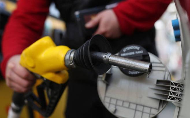 한 주유소에서 한 시민이 주유를 마친 후 주유 기계를 정리하고 있다. 연합뉴스